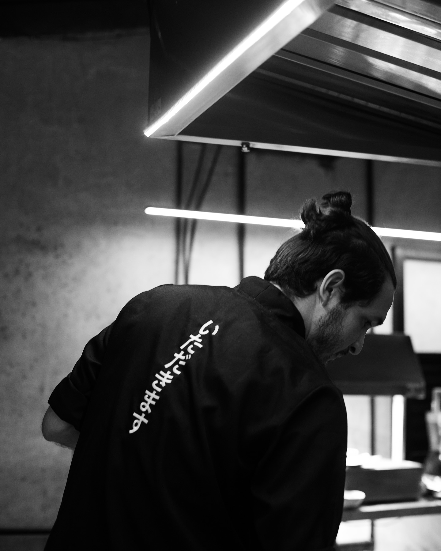 Chef de costas preparando omakase